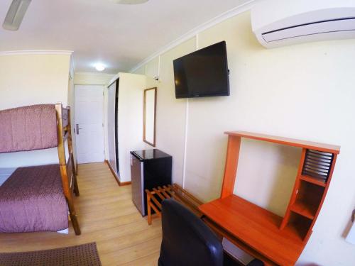 a room with a desk and a bed and a tv at Hotel San Francisco De la Selva in Copiapó