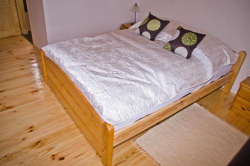 a small bed in a room with a wooden floor at Harmatcsepp-Vendégház in Kercaszomor