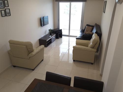 a living room with two chairs and a couch at Lighthouse by the Sea Lovely 2Bdr Apartment in Paphos City