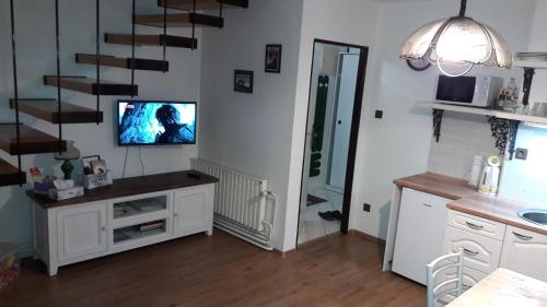 a living room with a tv and a staircase at Apartmány Modus 2 in Česká Ves