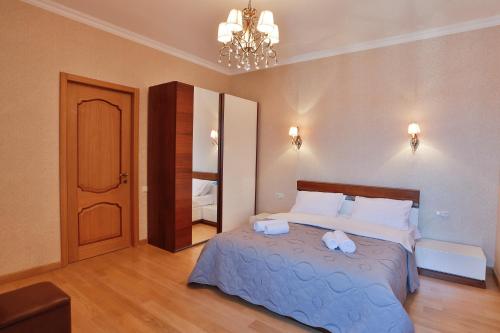 a bedroom with a large bed and a chandelier at Serviced Apartment on Rustaveli Avenue in Tbilisi City