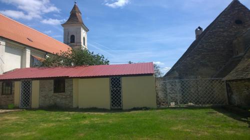 an old church with a red roof and a tower at Chalupa u kostela in Lukov