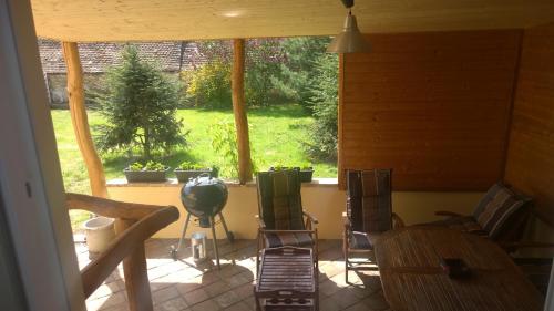 a screened in porch with chairs and a window at Chalupa u kostela in Lukov