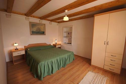 a bedroom with a green bed and two night stands at Apartments Imperial in Dubrovnik
