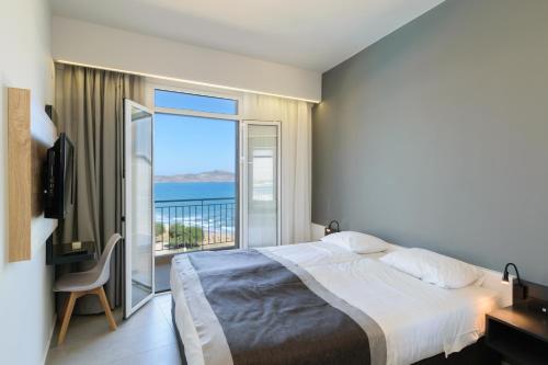 sypialnia z łóżkiem i widokiem na ocean w obiekcie Renieris Hotel w Stalós
