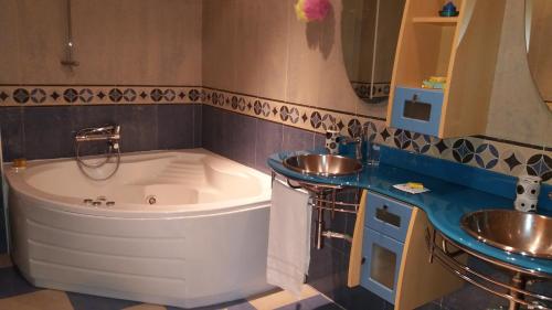a bathroom with a large tub and two sinks at Hotel Brezales in Espejón