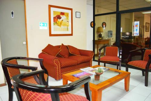 a living room with chairs and a table and a couch at Hotel San Francisco De la Selva in Copiapó