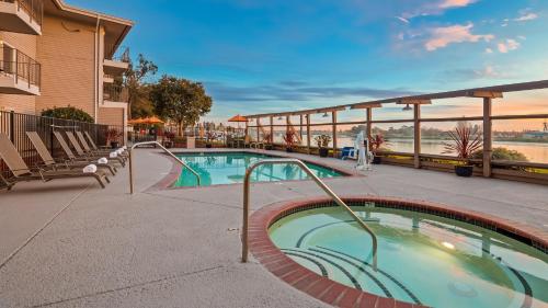 una piscina en un complejo con sillas y un edificio en Executive Inn & Suites Oakland en Oakland