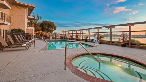 uma piscina num resort com cadeiras e um edifício em Executive Inn & Suites Oakland em Oakland