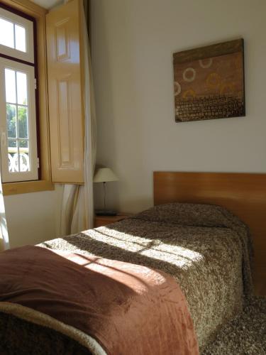 a bedroom with a bed and a window at Alojamento Cesarini in Montijo
