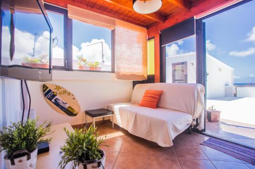 uma sala de estar com um sofá e algumas janelas em Eslanzarote Pico Colorado Loft in Soo, Super Wifi, Sat tv em Soo