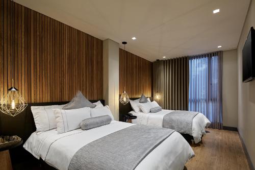 a hotel room with two beds and a window at 14 Urban Hotel in Medellín