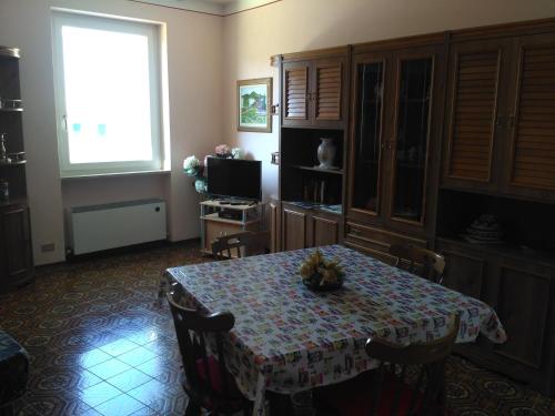 ein Esszimmer mit einem Tisch und einem Fenster in der Unterkunft Appartamenti Menapace in Torri del Benaco