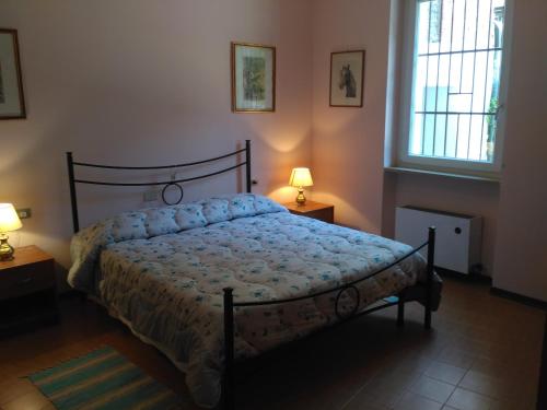 トッリ・デル・ベーナコにあるAppartamenti Menapaceのベッドルーム1室(ベッド1台、ランプ2つ、窓2つ付)