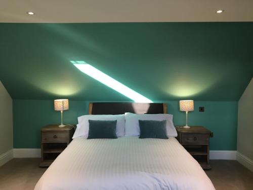 a bedroom with a large white bed with two lamps at Dunvegan Castle Keepers Cottage in Dunvegan