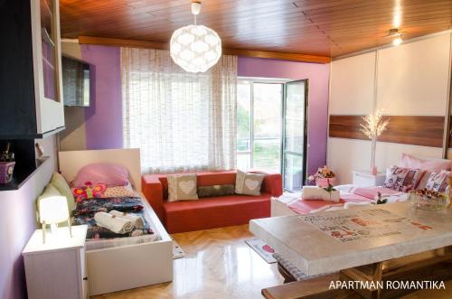a living room with a red couch and purple walls at Apartments Kamenecki in Krapina