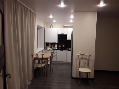 a room with a table and chairs and a kitchen at Apartment on Meretskova-Volosova in Velikiy Novgorod