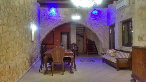 a dining room with a table and a stone wall at Venetian Cistern Villa in Kalamítsion Alexándrou
