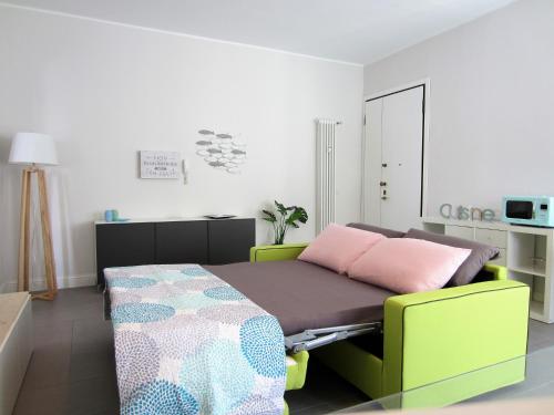 リミニにあるNew & modern apartment on the seaのベッドルーム1室(ピンクの枕が付いたベッド1台付)