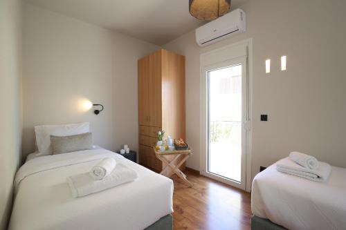a bedroom with two beds and a door to a window at Little Small Villa In Psychiko, Athens in Athens