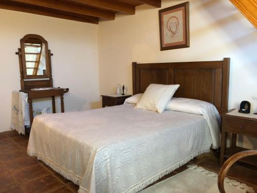 a bedroom with a white bed and a mirror at El Pajero de Erese in Erese
