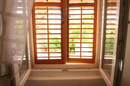 una ventana con persianas de madera en una habitación en Apartments Imperial, en Dubrovnik