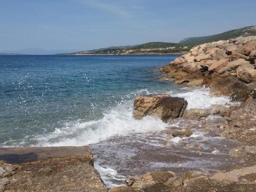 a body of water with waves crashing on the rocks at Hostel **Casa del Sole** in Klenovica