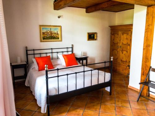 um quarto com uma cama com almofadas vermelhas em Bed and Breakfast Cascina Beccaris em Costigliole dʼAsti