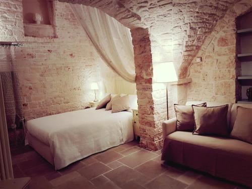 sypialnia z 2 łóżkami i kanapą w obiekcie Trulli D'Angiò w Alberobello
