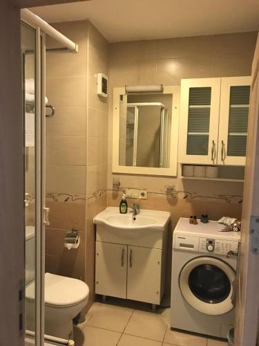 a bathroom with a toilet sink and a washing machine at Taksim House Suites in Istanbul