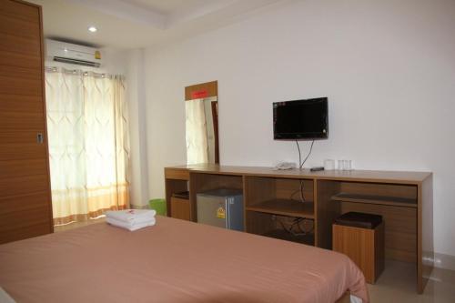 a bedroom with a bed and a desk with a computer at The Ocean Residence in Nakhon Ratchasima