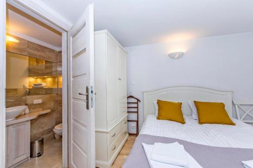 ソポトにあるCarlo Rentyear Apartmentsのベッドルーム(白いベッド、黄色い枕付)