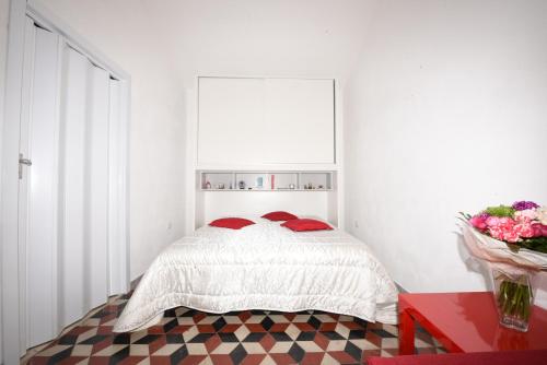 カステッランマーレ・デル・ゴルフォにあるTerrazza in Palazzo Taorminaの白いベッドルーム(赤い枕のベッド付)