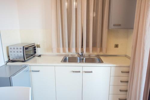 a small kitchen with a sink and a microwave at Mais Studios in Vatera