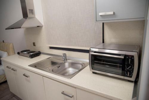 a kitchen with a sink and a microwave at Mais Studios in Vatera