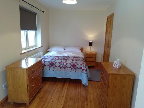 a bedroom with a bed and a wooden floor at Townhouse 4 Barrow Lane in Carlow
