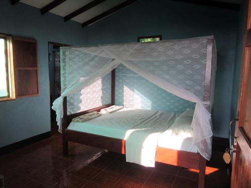 Bett mit Baldachin in einem Zimmer in der Unterkunft Caballito's Mar in Mérida