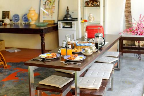 einen Tisch mit Teller mit Lebensmitteln in der Küche in der Unterkunft Casugria Dutch Residence 1810 in Malakka