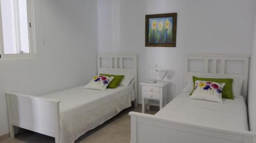 two white beds in a room with at Sonder in Caleta De Fuste