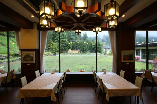 a dining room with two tables and a large window at Nozawa Grand Hotel in Nozawa Onsen