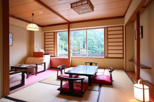 a room with a table and chairs and a window at Nozawa Grand Hotel in Nozawa Onsen