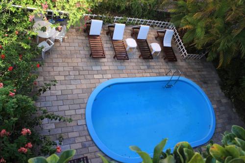 an overhead view of a pool with chairs and a table at Pousada Beijos y Abraços in Natal