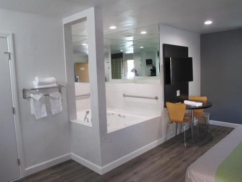 a bathroom with a tub and a large mirror at Claremont Lodge in Claremont