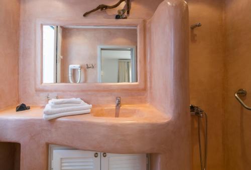 a bathroom with a sink and a mirror at Giannoulis Hotel in Adamantas