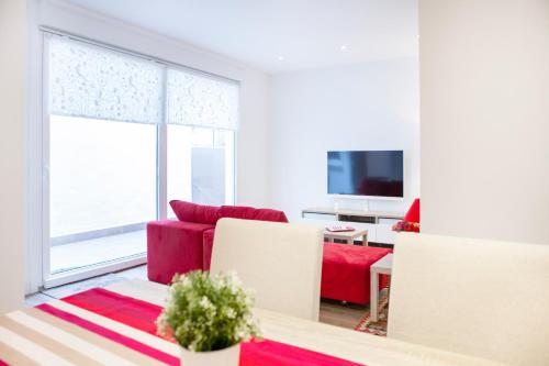 サン・セバスティアンにあるARRASATE (new apartment in city center )の赤いソファとテーブルのあるリビングルーム