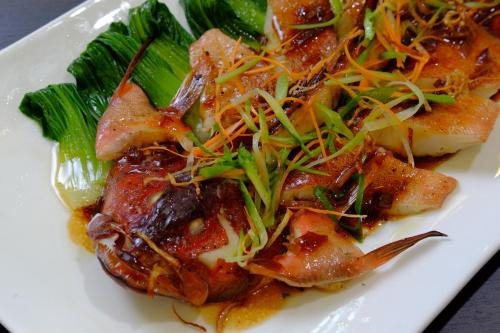 a white plate of food with shrimp and vegetables at One Central Hotel & Suites in Cebu City