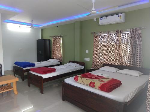 a room with three beds in it with blue lights at Gorumara Nature's Cottage (A Unit Of M/S Ecological & Tours) in Jalpāiguri