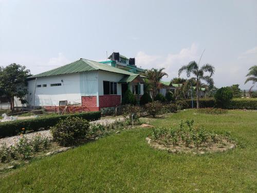 a house with a garden in front of it at Gorumara Nature's Cottage (A Unit Of M/S Ecological & Tours) in Jalpāiguri
