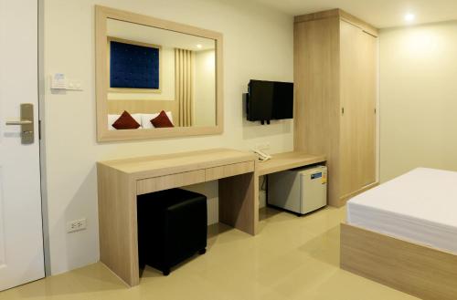 a hotel room with a desk and a mirror at DB Plus 3 in Bangkok