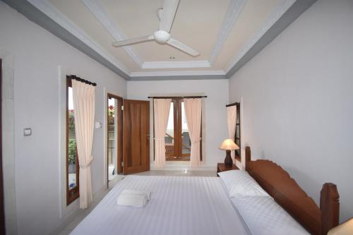 a bedroom with a bed and a ceiling at Sania's House in Ubud